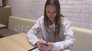 女人<strong>正在</strong>手机上<strong>输入</strong>一条信息，坐在咖啡馆里等人。